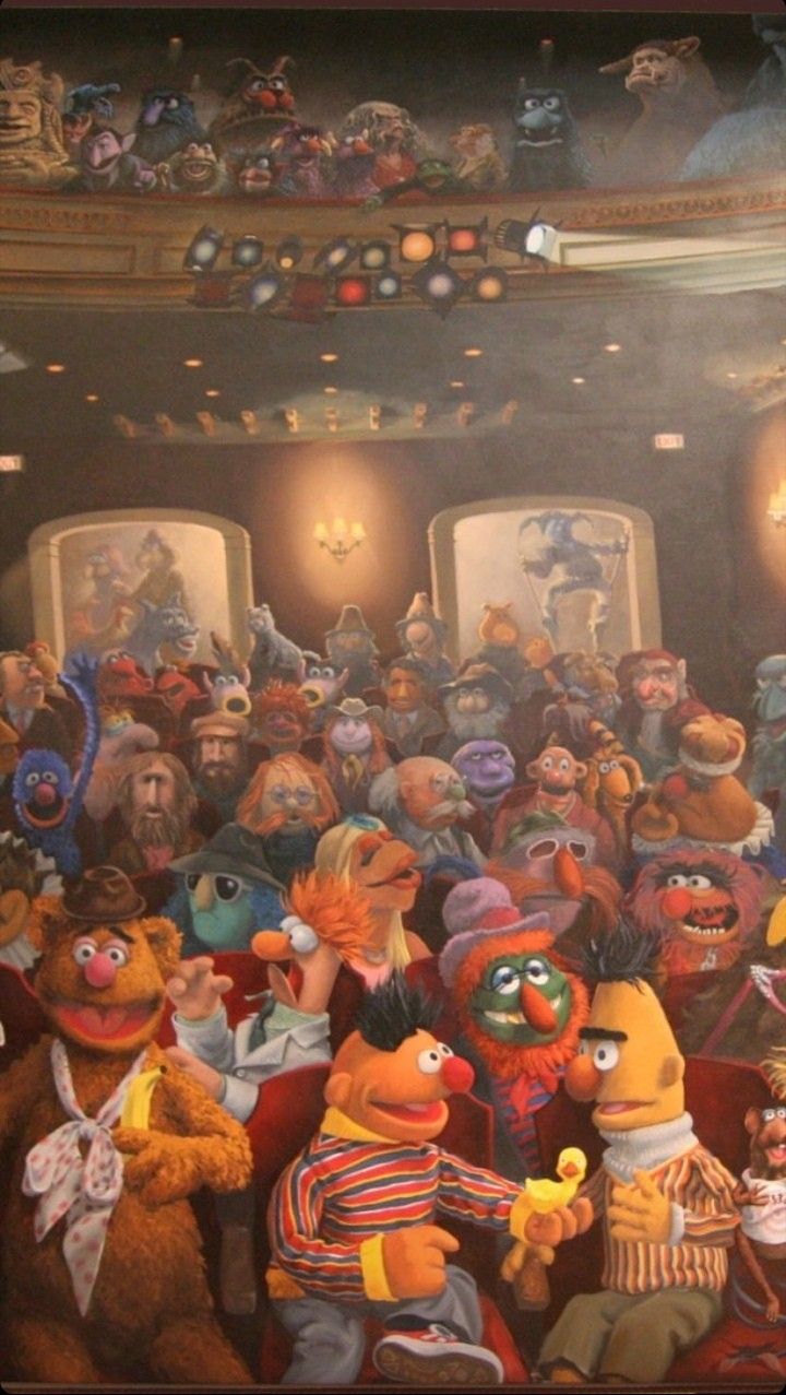 a group of sesame characters sitting in front of a crowd of people with stuffed animals