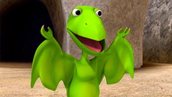 a green cartoon character waving in front of a cave