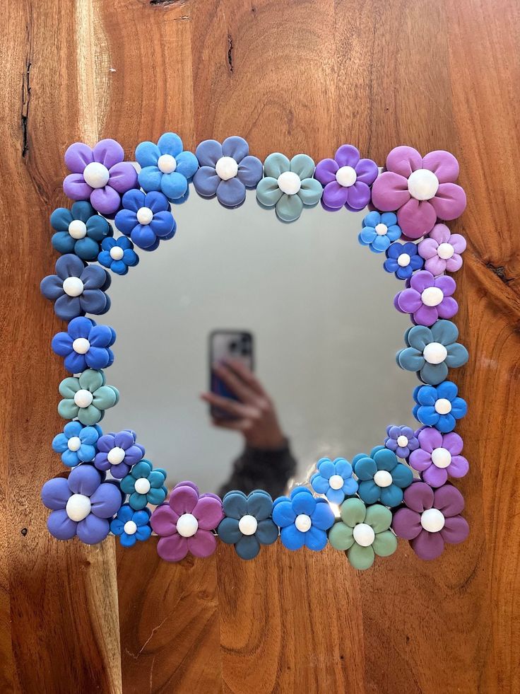 a person taking a selfie in front of a mirror with flower decorations on it