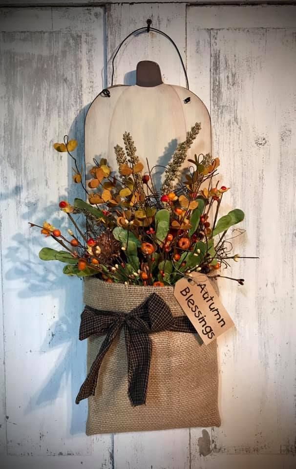 a burlock hanging from the side of a wall with flowers and leaves in it