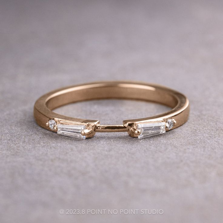 a gold wedding band with three baguettes on the side and two diamonds in the middle