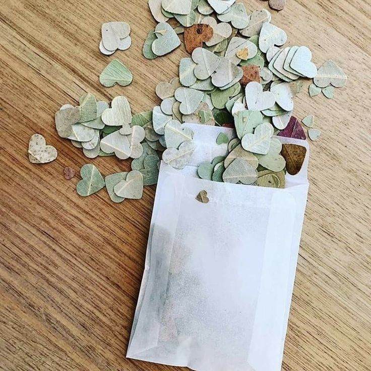 a bag filled with hearts sitting on top of a wooden table next to a pile of rocks