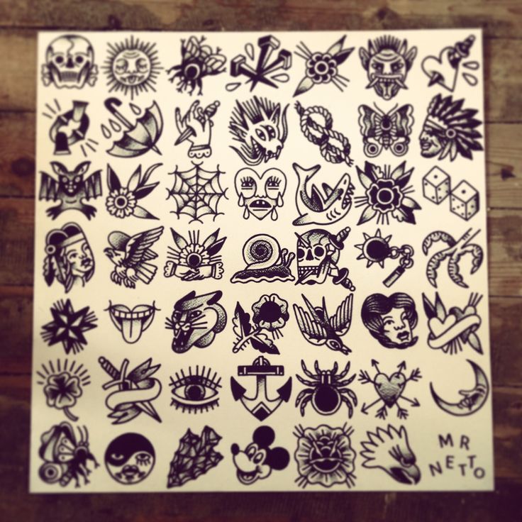 a bunch of tattoos on a piece of paper sitting on top of a wooden table