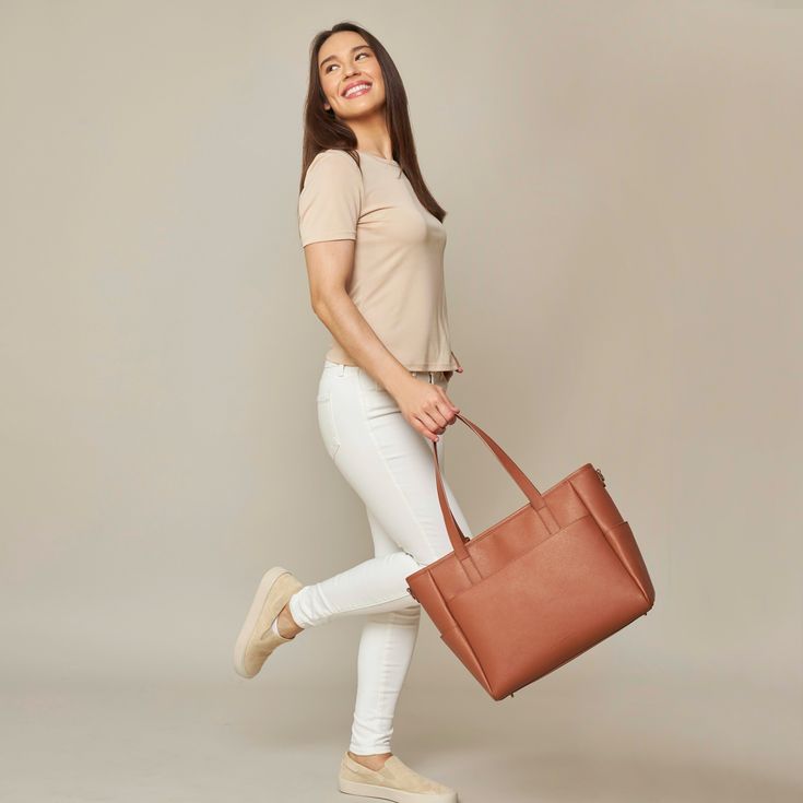 This structured tote is the ultimate do-it-all bag that you deserve. It's the perfect carryall for work, travel, and anywhere your day brings you. It features a spacious and organized interior for your essentials, a padded compartment for your laptop, side pockets for your drinks, and you can convert it into a backpack or crossbody. Crafted from premium American Saffiano leather that's waterproof and scratch-resistant, the Transform Tote will stay just as beautiful through all your travels and a Tote Shoulder Bag With Luggage Sleeve, Classic Weekender Bag With Large Capacity For Shopping, Classic Large Capacity Weekender Bag For Shopping, Classic Large Capacity Weekender Bag, Classic Weekender Bag For Shopping, Chic Laptop Bag With Removable Pouch For On-the-go, Cognac Weekender Bag For Daily Use, Cognac Tote Weekender Bag For Travel, Everyday Cognac Briefcase With Luggage Sleeve