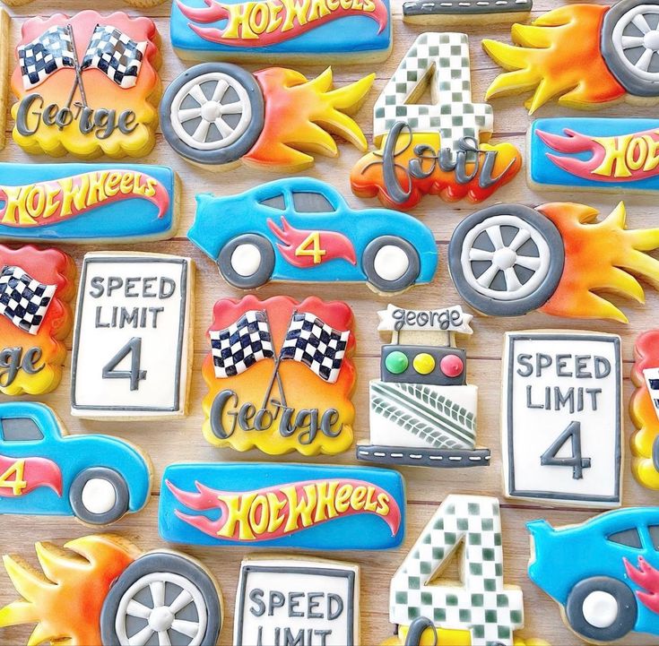 decorated cookies with cars and hot wheels on top of a wooden table in the shape of numbers