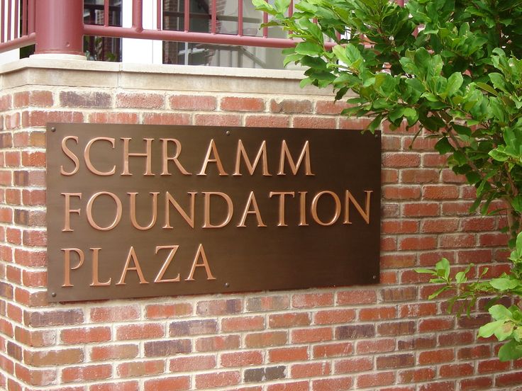 a sign on the side of a brick building that says schramm foundation plaza