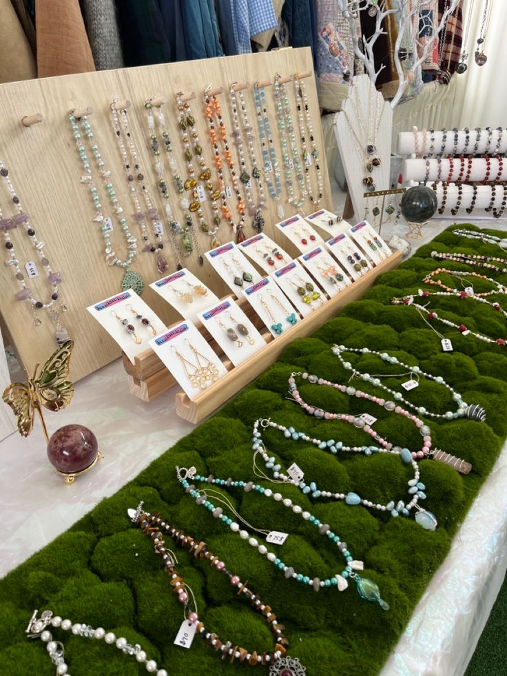 a table topped with lots of necklaces on display