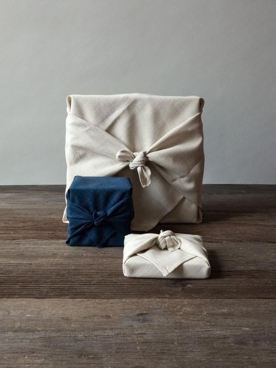 a white and blue blanket sitting on top of a wooden floor next to a pair of shoes