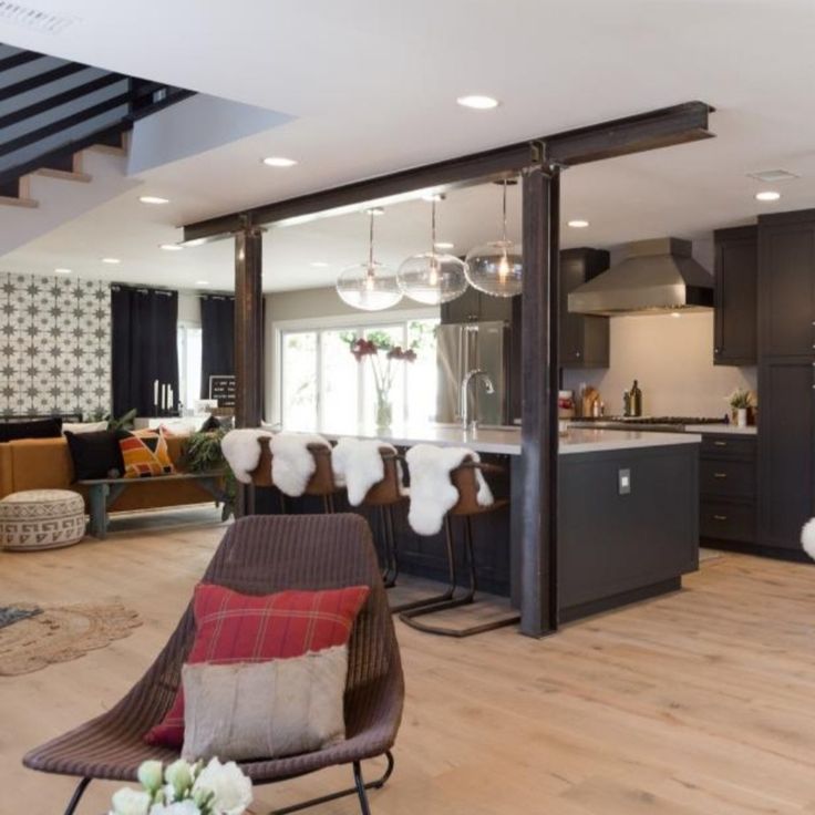 a living room filled with furniture next to a kitchen and an open floor plan on top of a hard wood floor