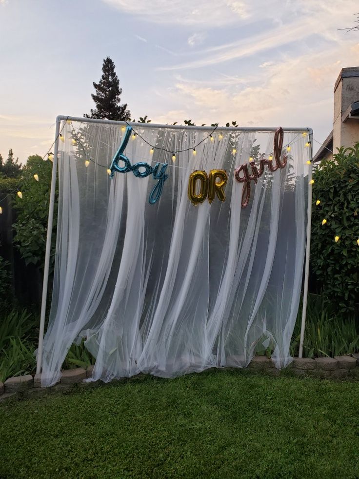 a sign that says baby on it hanging from the side of a fence with lights