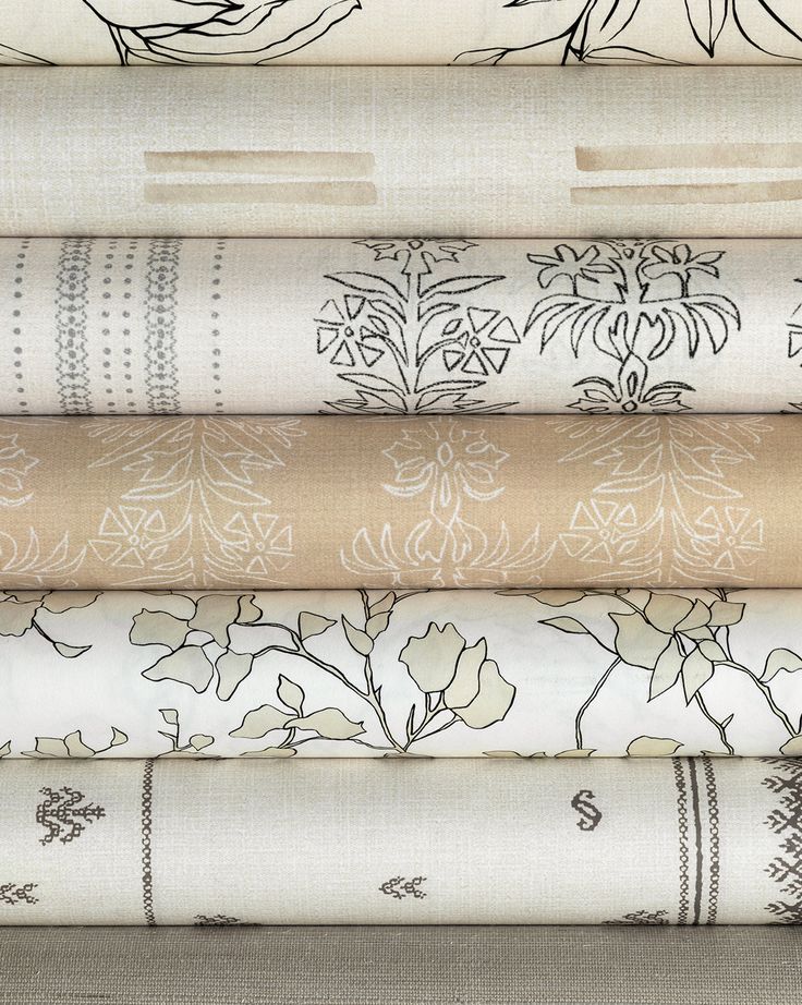 a stack of different types of fabric with flowers and leaves on them, all in various colors