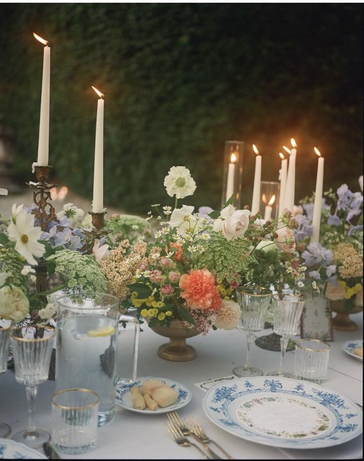 the table is set with flowers and candles