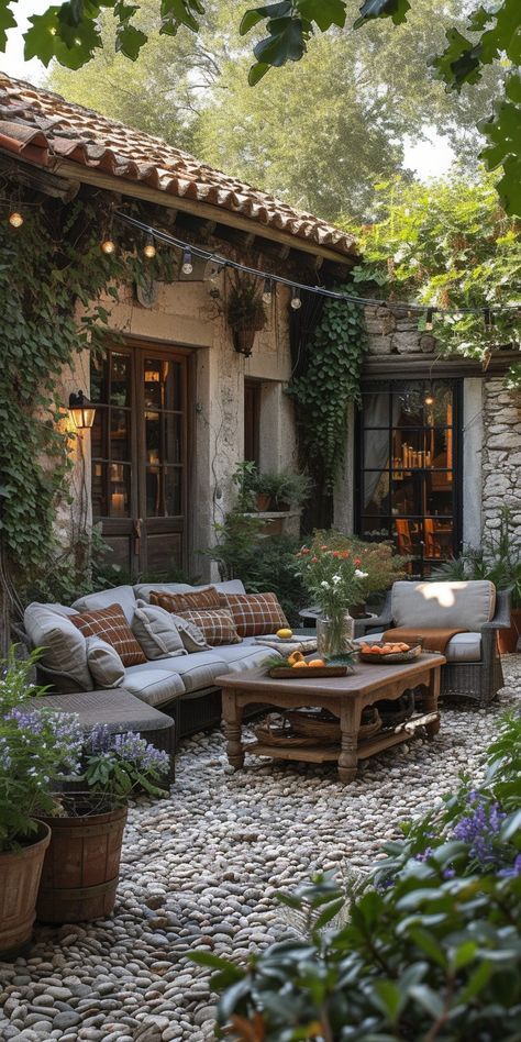 an outdoor living area with couches, tables and potted plants