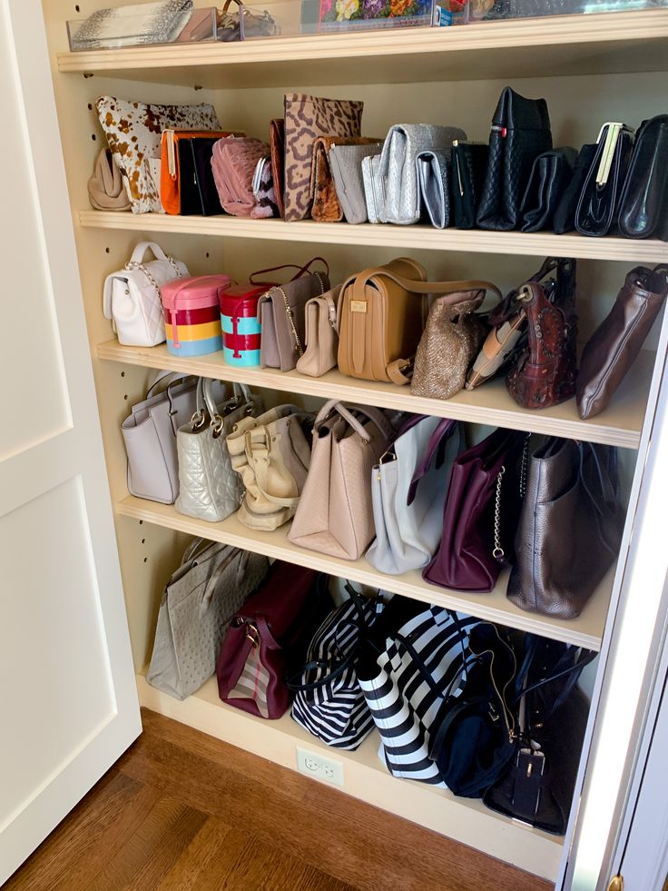 a closet filled with lots of purses and handbags on shelving unit next to door