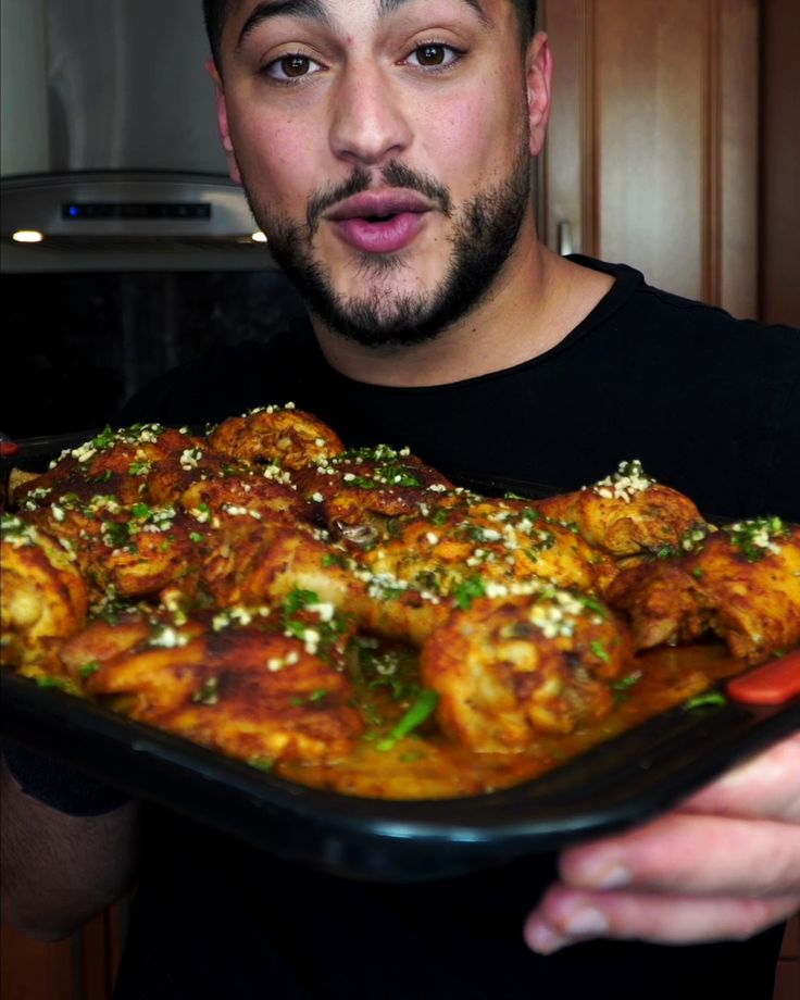 a man holding a tray full of food in his hands and making a funny face