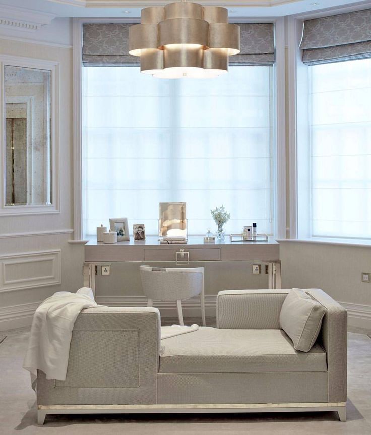 a living room filled with furniture next to a large window covered in white drapes