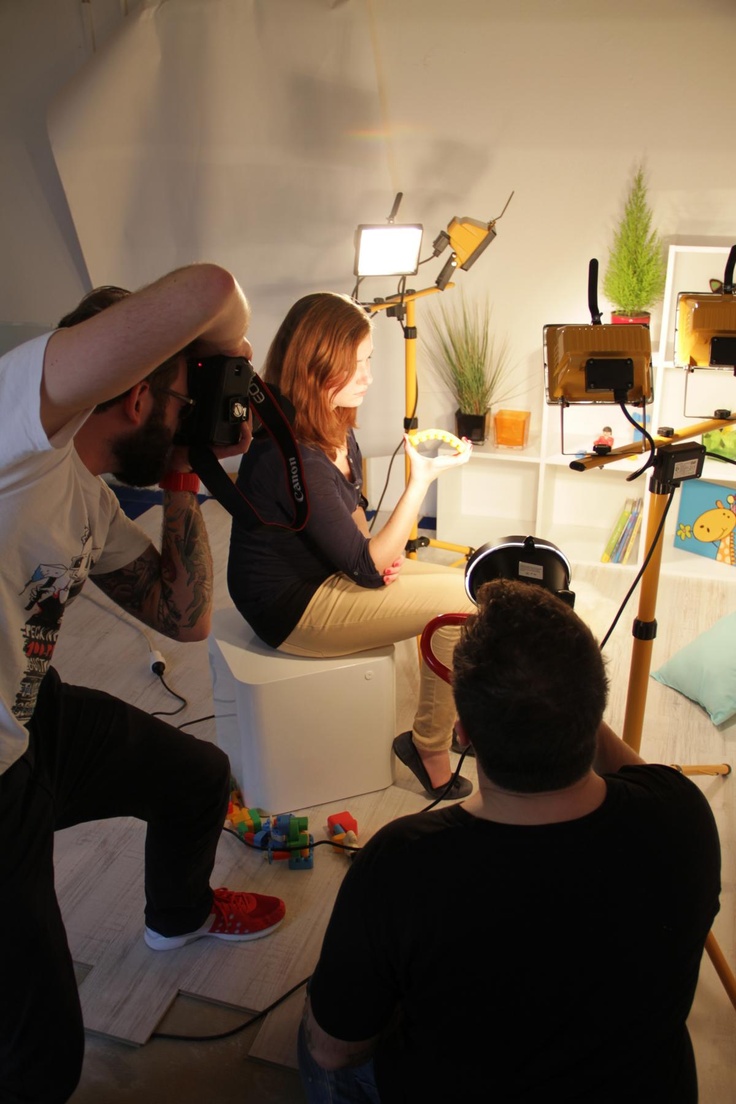 a man and woman sitting in front of a camera on top of a white chair