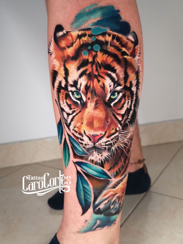 a tiger with feathers on his leg is shown in this tattoo art photo by carol clark