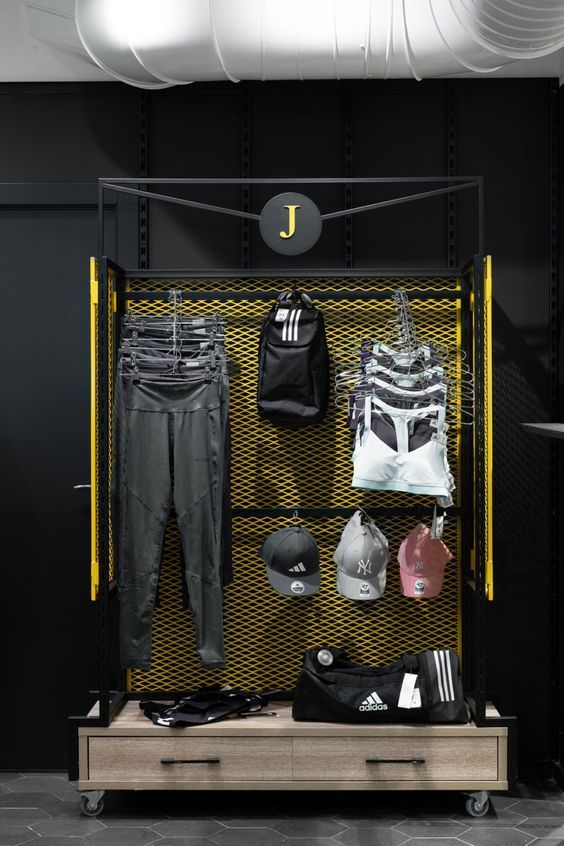 a display case with clothes and sports equipment on the shelves in front of it, along with other items