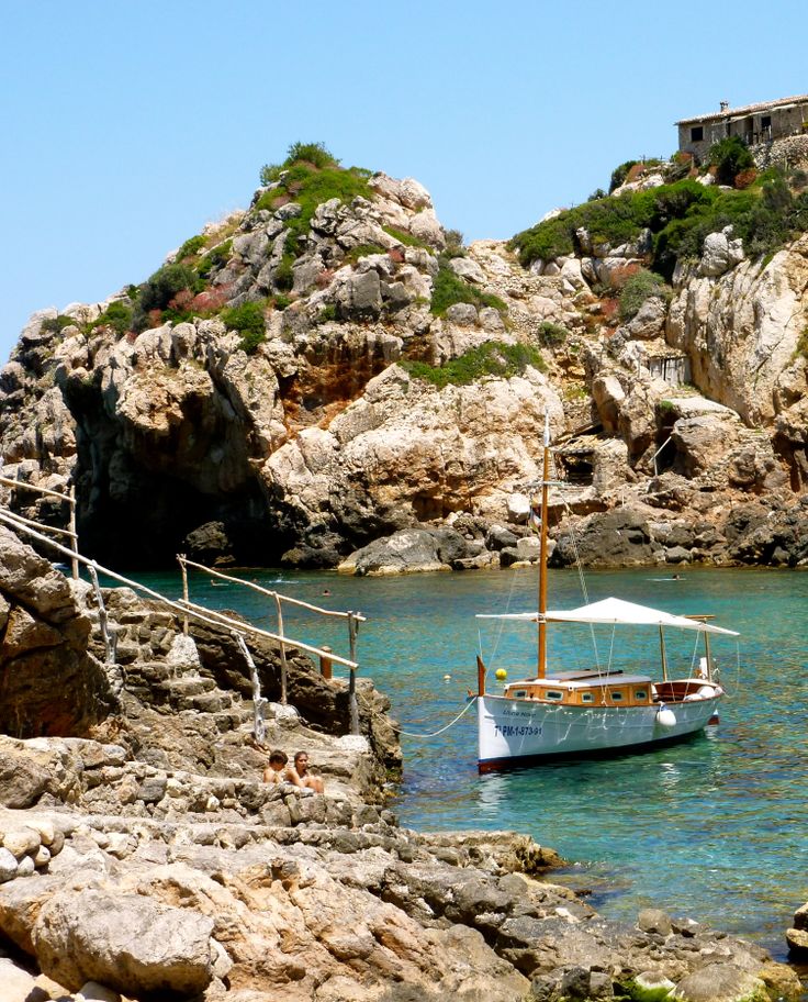 a small boat in the water near some rocks