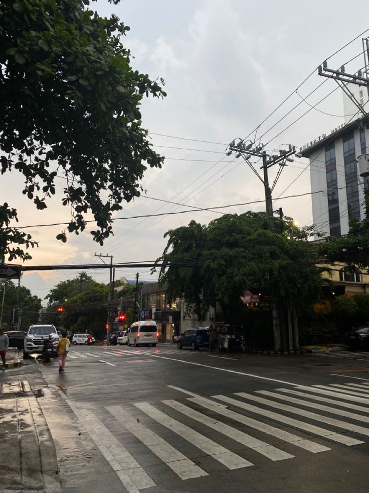 an intersection with cars and people crossing the street