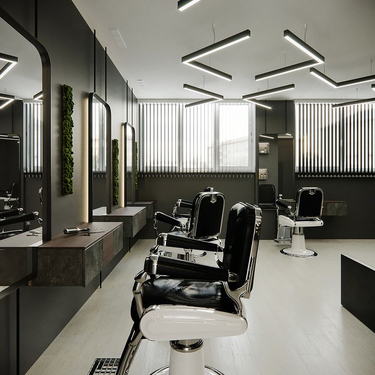 a salon with black and white chairs and mirrors on the walls, lights above them