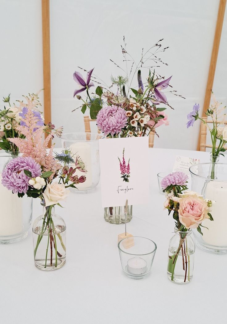 there are many vases with flowers on the table