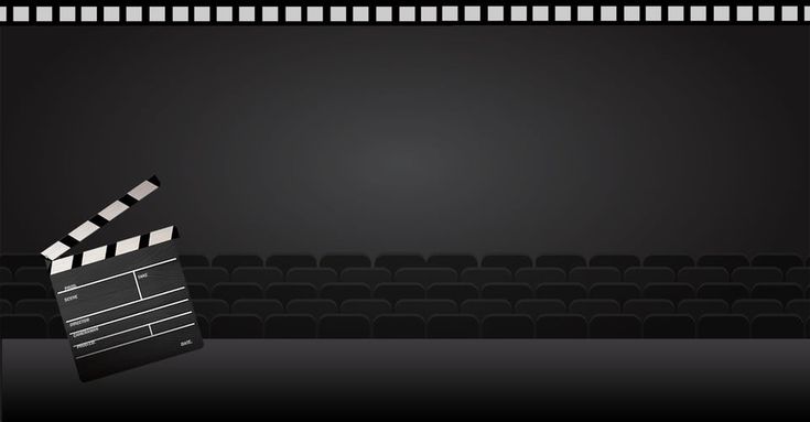 a black and white photo of a movie clapper in front of an empty auditorium