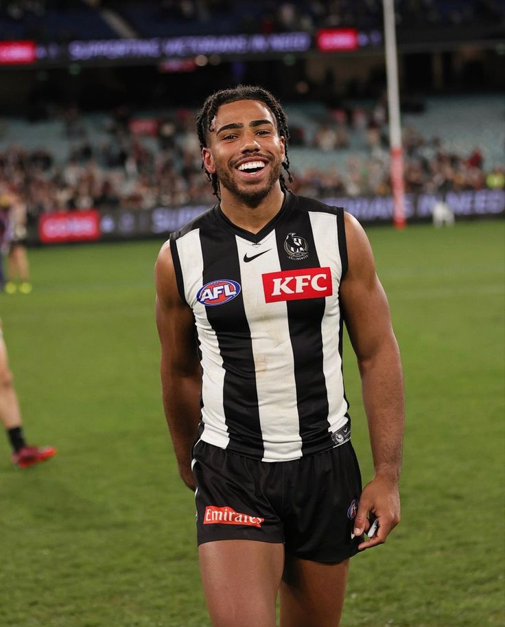 a man standing on top of a soccer field wearing a black and white striped uniform