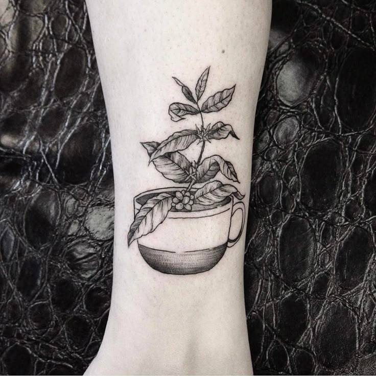 a black and white photo of a plant in a pot on the ankle tattoo design