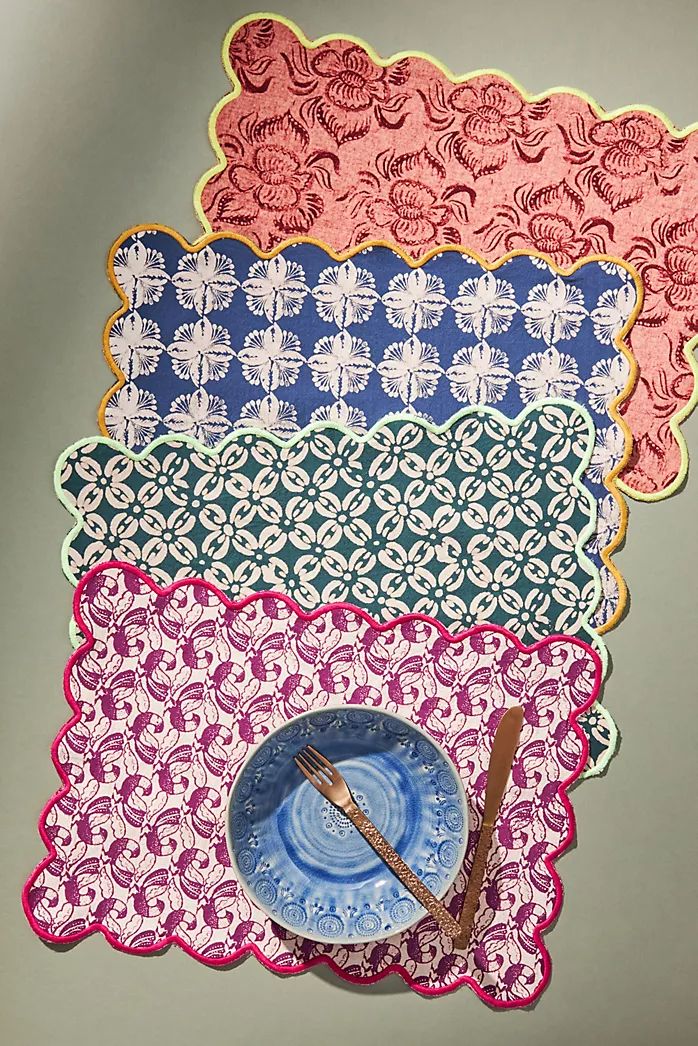 four placemats with different designs on them, one blue plate and the other pink