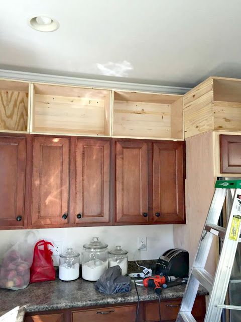 a kitchen with wooden cabinets and ladders in the middle of the counter top area