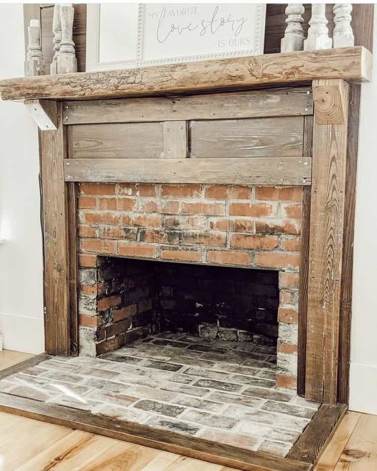 an old brick fireplace in a room with wood flooring and white paint on the walls