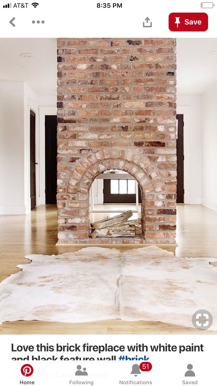 an empty room with a brick fireplace in the center and white carpet on the floor