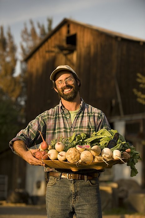 a man holding a basket full of vegetables