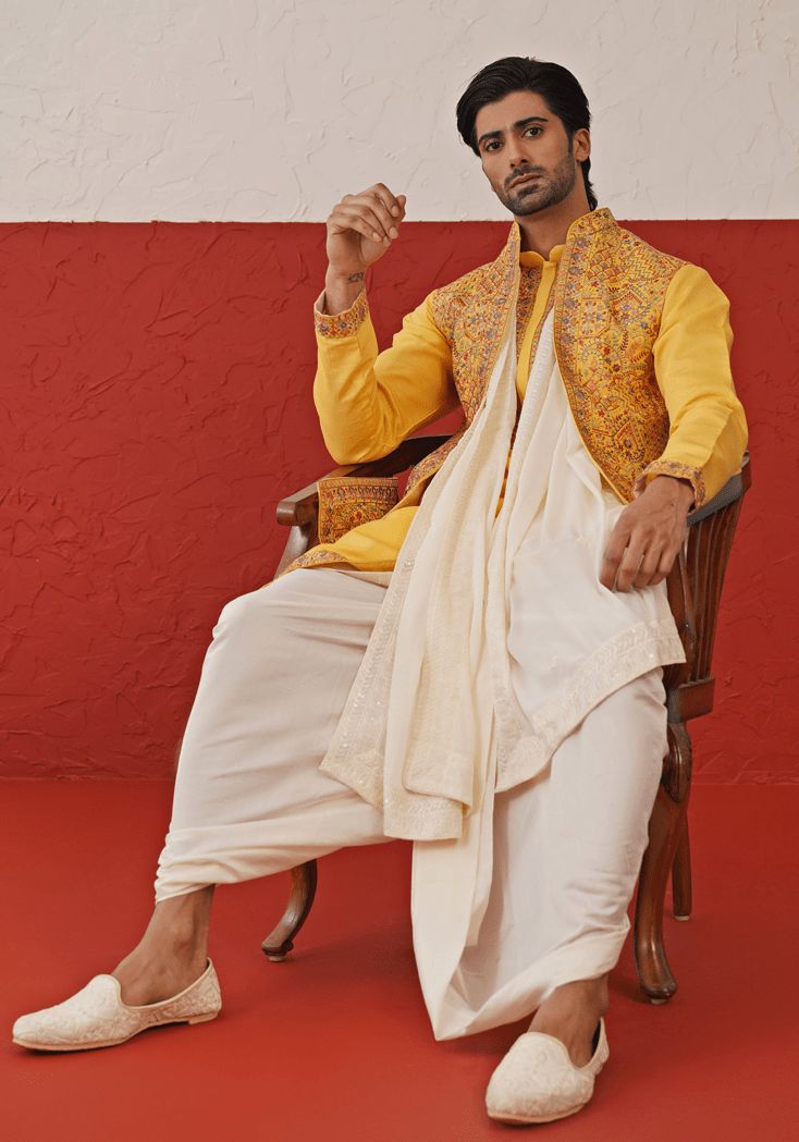 Elevate your style with Yellow Kurta. Crafted from georgette, the kurta features exquisite Resham and sequinned embroidery, a detailed yoke design, and cuffs. Paired with an ivory dhoti and an embroidered dupatta. Perfect for special occasions like Sangeet, Mehendi, Haldi, or as a wedding guest outfit. Composition : Kurta, Dhoti & Dupatta : Viscose Georgette Care: Dry Clean Only and Vacuum Storage This product can be customized for sleeves, length and colour Delivery : 2-4 weeks as the product i Embroidered Slub Silk Sherwani With Traditional Drape, Traditional Embroidered Slub Silk Sherwani, Bollywood Style Embroidered Slub Silk Sherwani, Traditional Slub Silk Sherwani For Transitional Season, Unstitched Slub Silk Sherwani For Transitional Seasons, Transitional Unstitched Slub Silk Sherwani, Festive Slub Silk Sherwani, Festive Transitional Slub Silk Sherwani, Designer Slub Silk Sherwani For Festivals