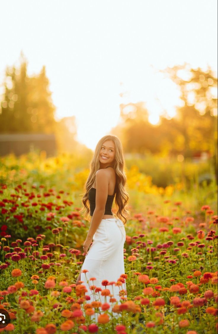 a woman standing in a field of flowers