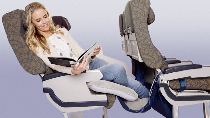 a woman sitting in a reclining chair reading a book