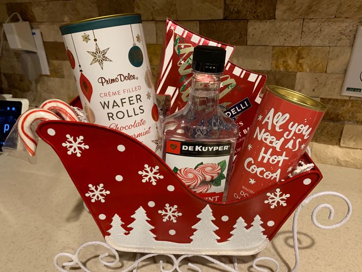 a red and white sleigh filled with christmas items sitting on top of a counter