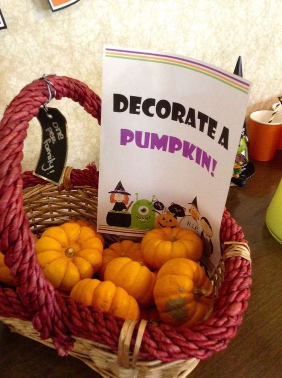 a basket filled with lots of oranges sitting on top of a table next to a sign