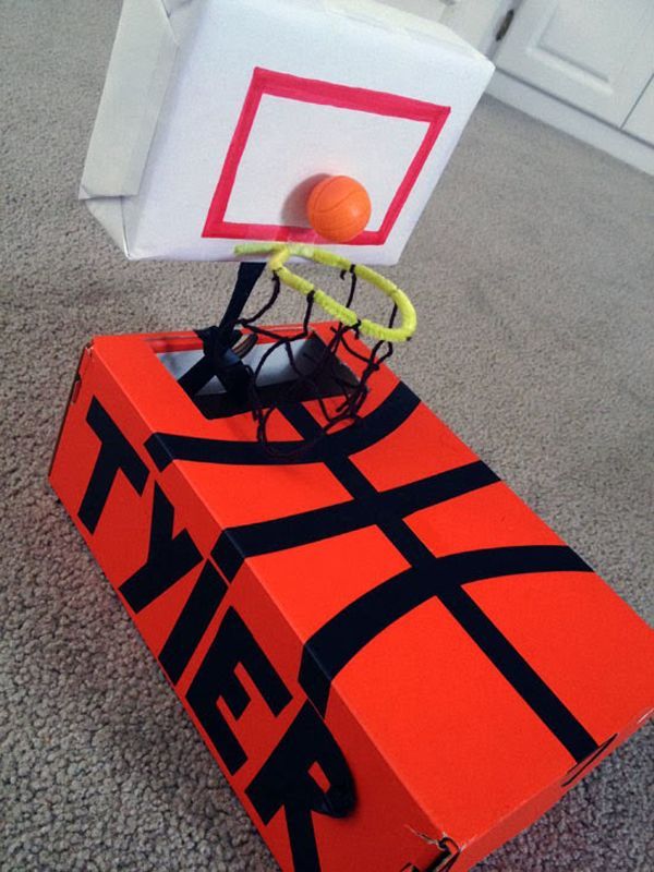 an orange and black box with a basketball in it's net on the floor