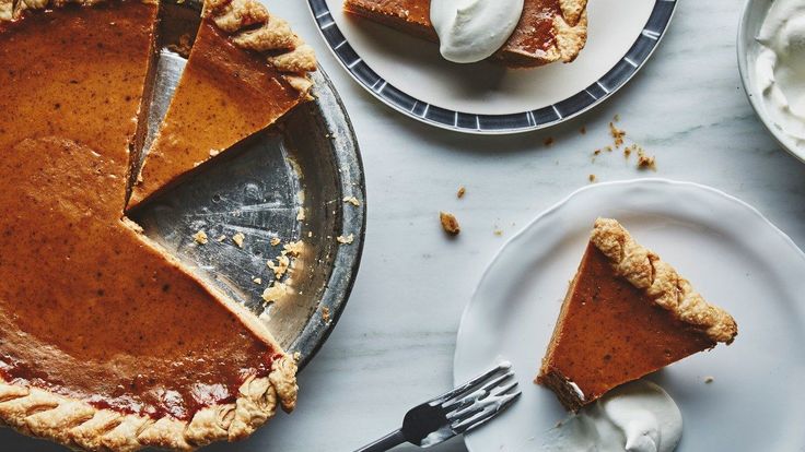 two plates with slices of pie and whipped cream