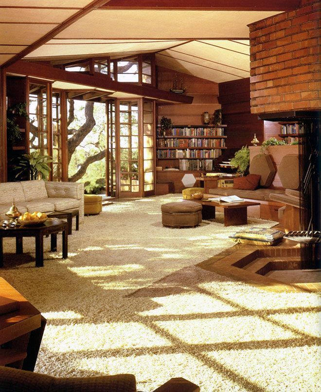 a living room filled with furniture and a fire place in the middle of it's walls