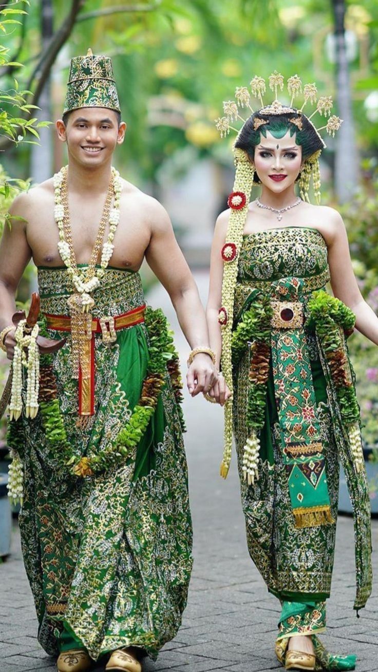 two people dressed in costume walking down a street together, one holding the hand of another person's hand