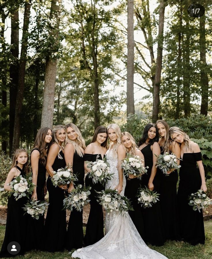 a group of women in black dresses standing next to each other with bouquets on their heads