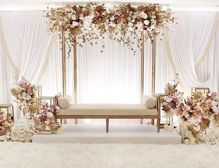 a white and gold wedding set up with flowers