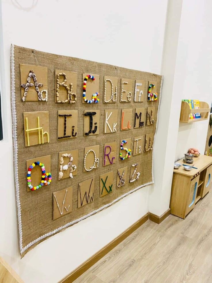 a wall hanging with letters and numbers made out of burlocked paper on it