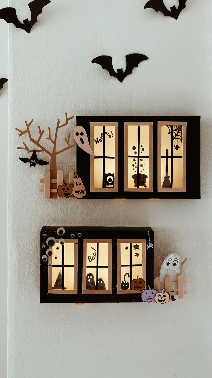 two shelves with halloween decorations on them and bats hanging from the wall behind them,