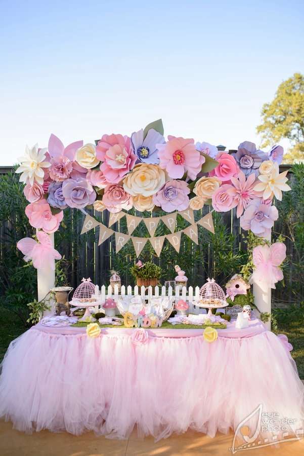 an image of a table set up for a party with flowers and buntings