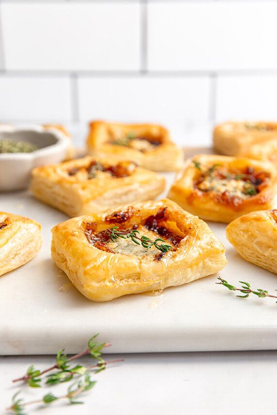 small pastries on a cutting board with herbs